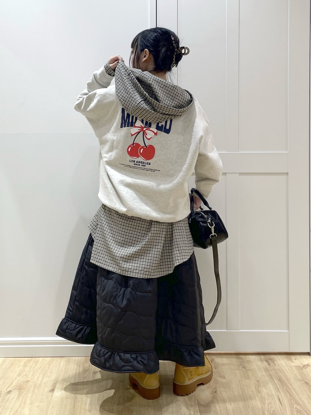 ベージュ系のブーツ、ブラック系のスカート、ベージュ系のスウェットを着用したレディースの秋コーディネートの3枚目の写真