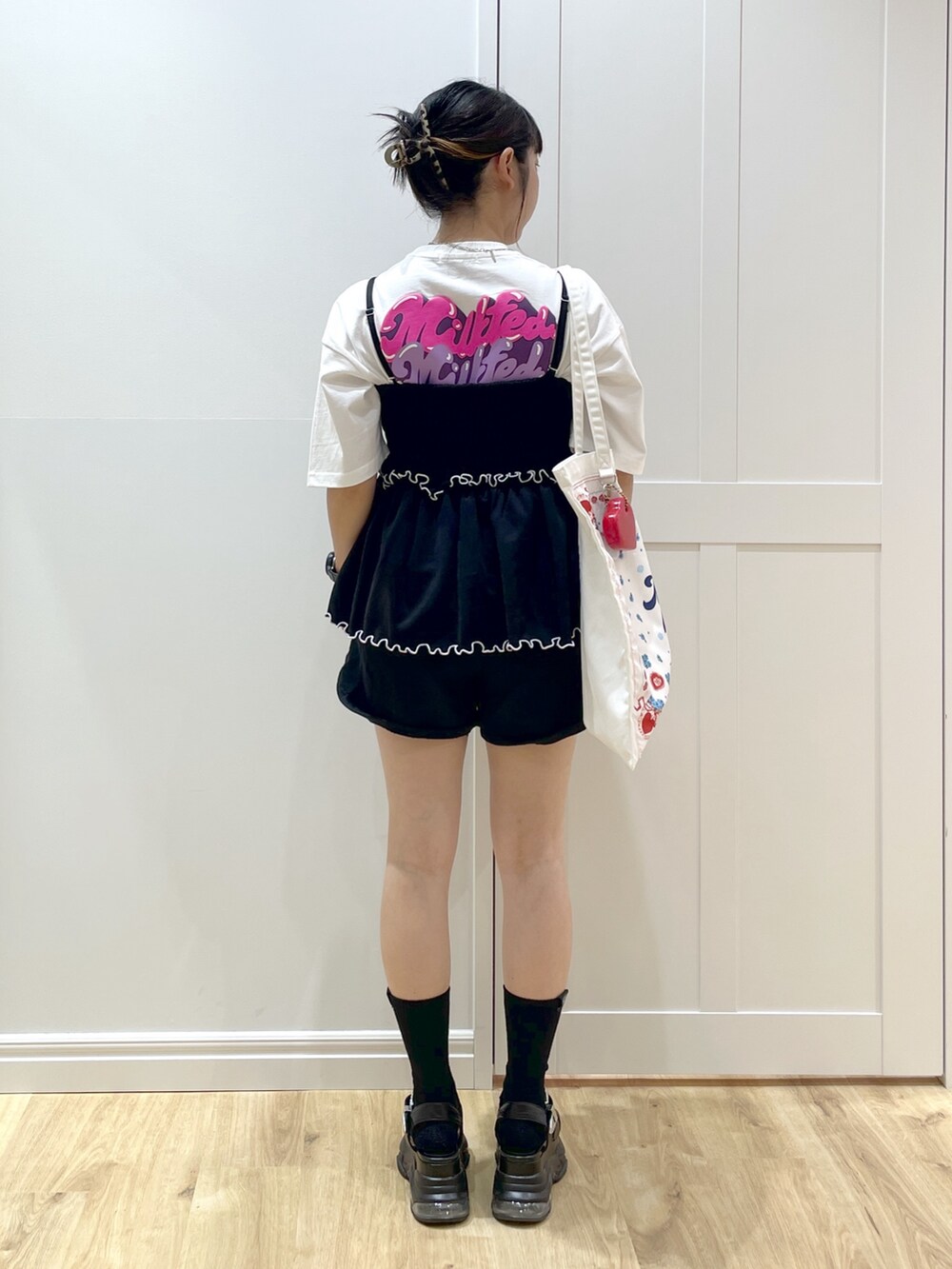 ブラック系のスウェットパンツ、ブラック系のキャミソール、ホワイト系のTシャツ/カットソーを着用したレディースの夏コーディネートの3枚目の写真