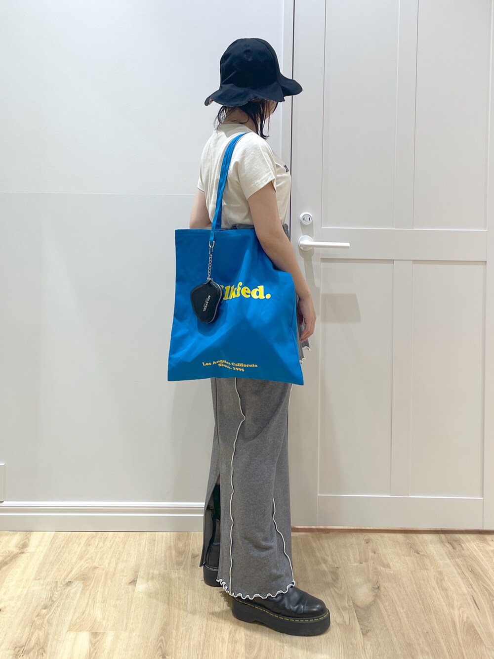 グレー系のキャミソール、グレー系のスカート、ブラック系のブーツを着用したレディースの春コーディネートの2枚目の写真