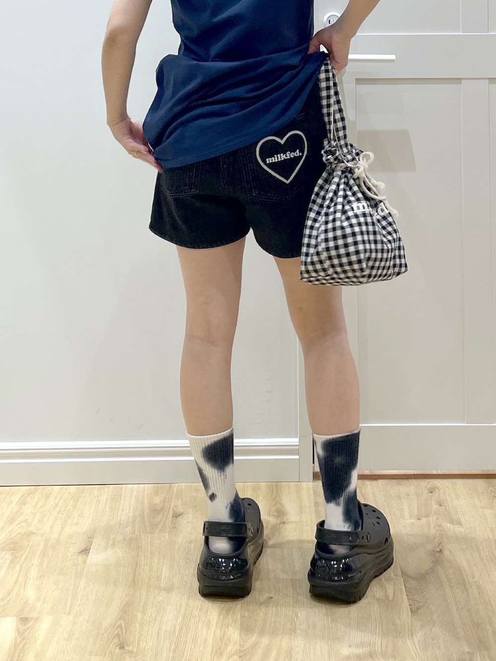 ブラック系のサンダル、ブラック系のデニムパンツ、ブルー系のワンピースを着用したレディースの夏コーディネートの5枚目の写真