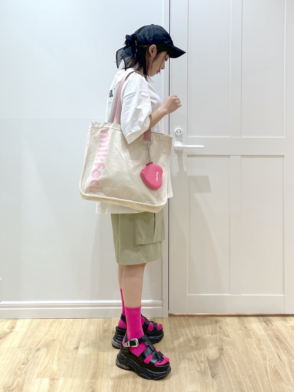 ホワイト系のTシャツ/カットソー、ブラック系のサンダル、ホワイト系のトートバッグを着用したレディースの夏コーディネートの3枚目の写真