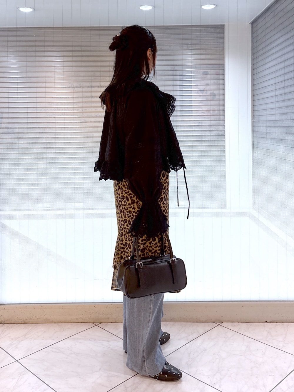 ブラック系のその他シューズ、ブルー系のデニムパンツ、ベージュ系のスカートを着用したレディースの春コーディネートの3枚目の写真