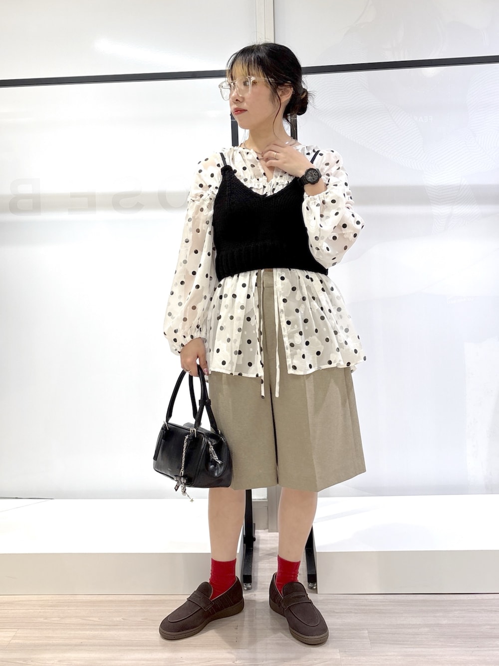 ホワイト系のシャツ/ブラウス、ブラック系のニット/セーター、ベージュ系のテーラードジャケットを着用したレディースの春コーディネートの4枚目の写真