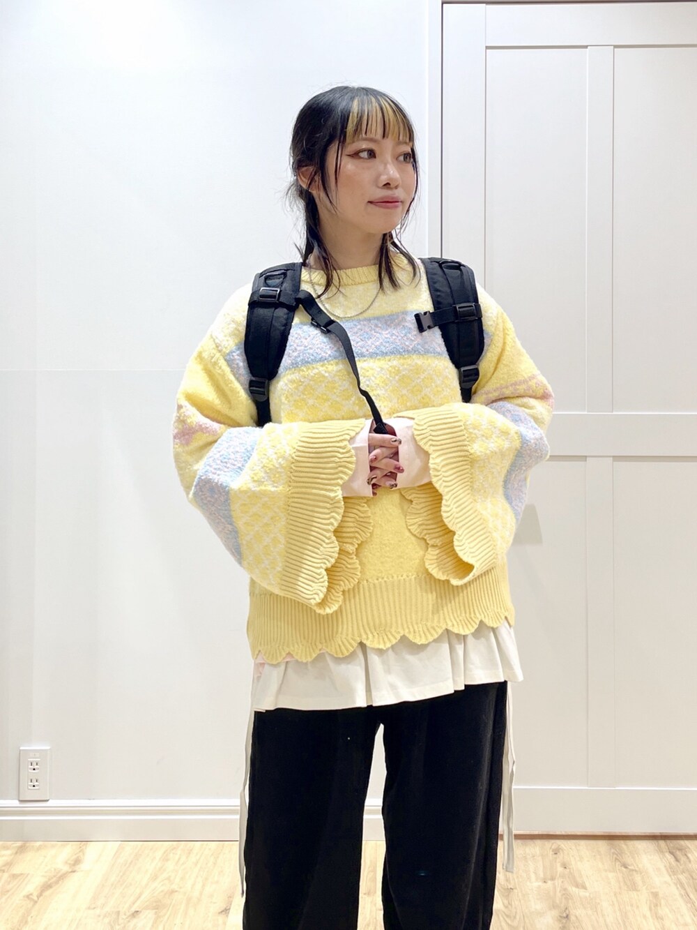 ピンク系のTシャツ/カットソー、イエロー系のニット/セーター、ブラック系のスウェットパンツを着用したレディースの秋コーディネートの4枚目の写真