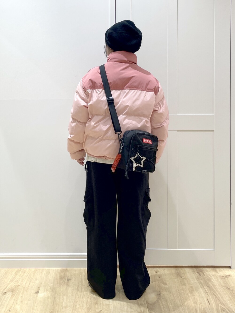 ブラック系のスウェットパンツ、ピンク系のダウンジャケット/コート、ベージュ系のTシャツ/カットソーを着用したレディースの冬コーディネートの2枚目の写真