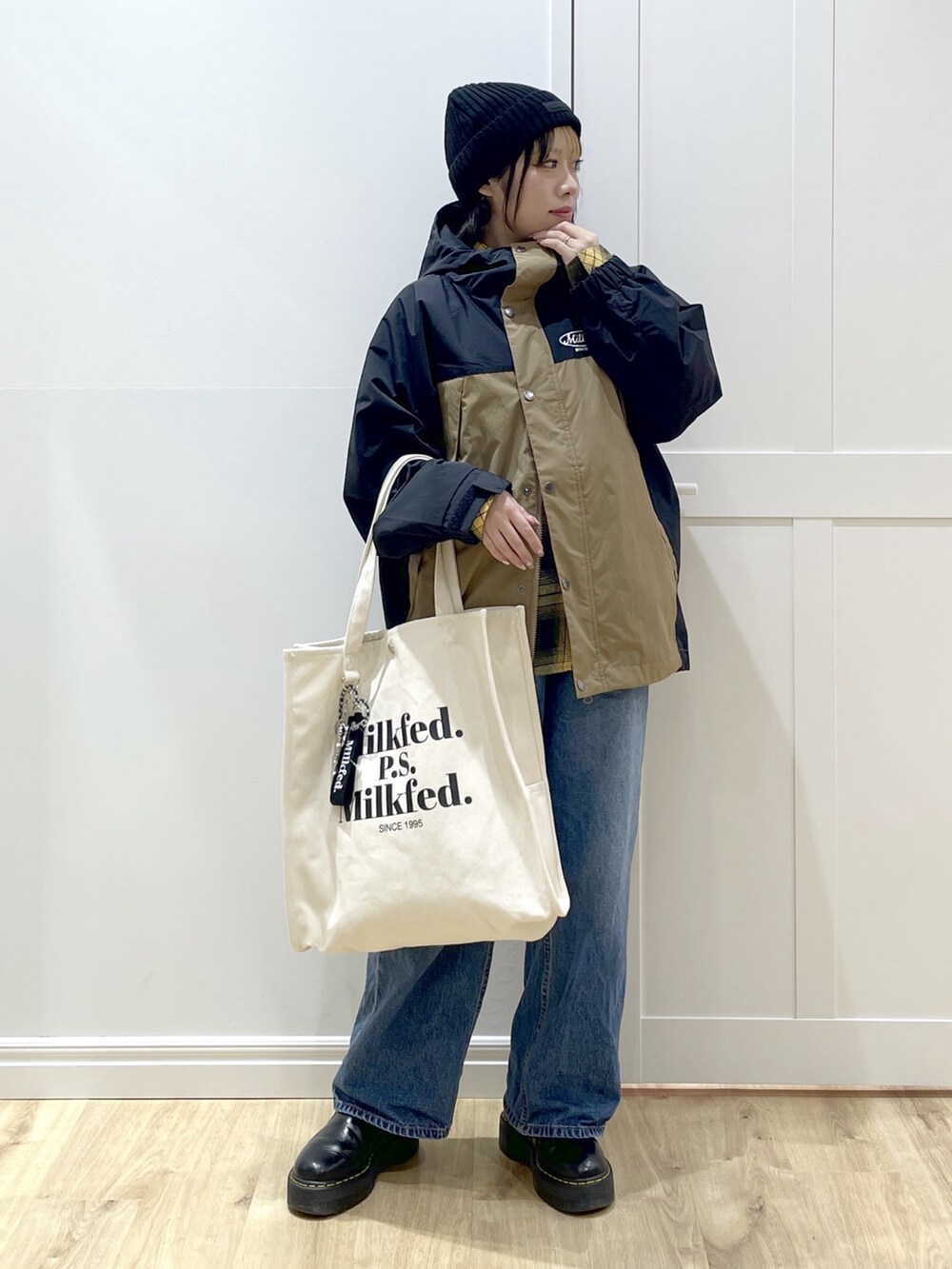 ブルー系のデニムパンツ、イエロー系のシャツ/ブラウス、ベージュ系のマウンテンパーカーを着用したレディースの冬コーディネートの4枚目の写真