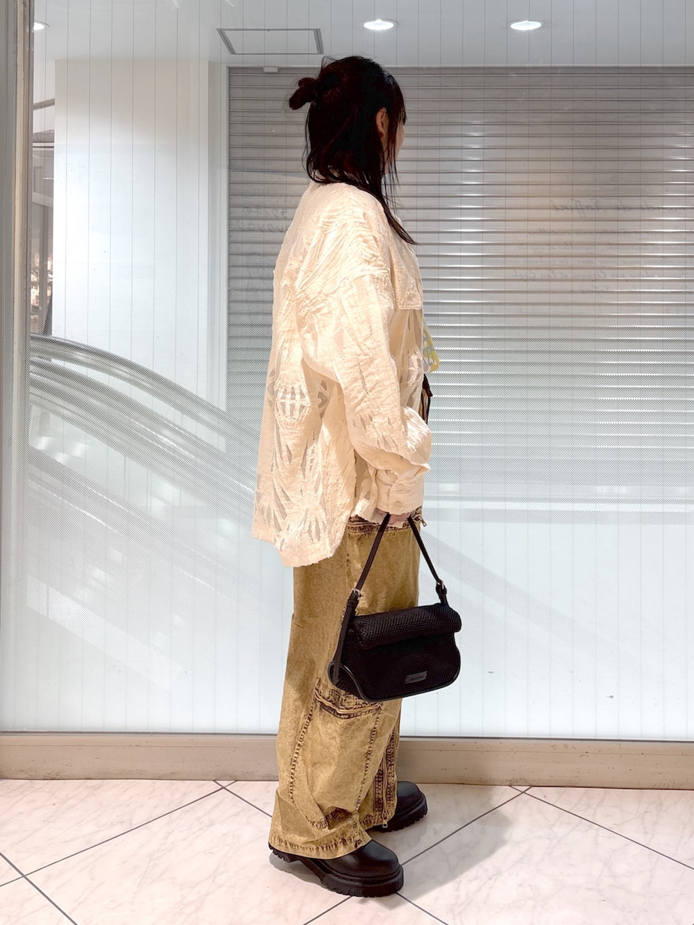 ブラック系のブーツ、ホワイト系のTシャツ/カットソー、ブラック系のショルダーバッグを着用したレディースの春コーディネートの2枚目の写真