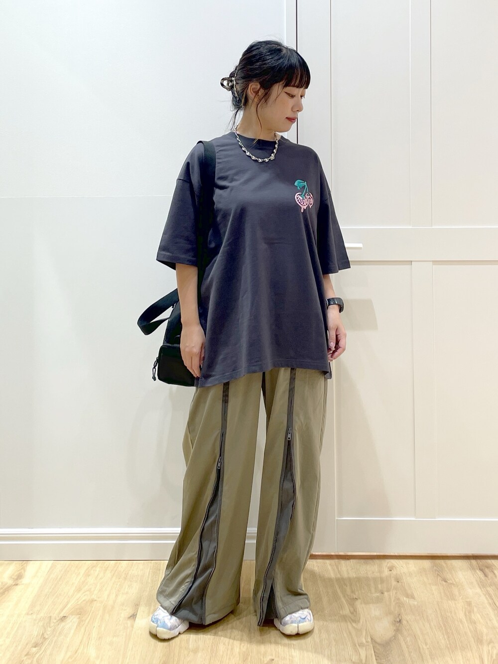 グリーン系のその他パンツ、グレー系のTシャツ/カットソー、レッド系のショルダーバッグを着用したレディースの夏コーディネートの5枚目の写真