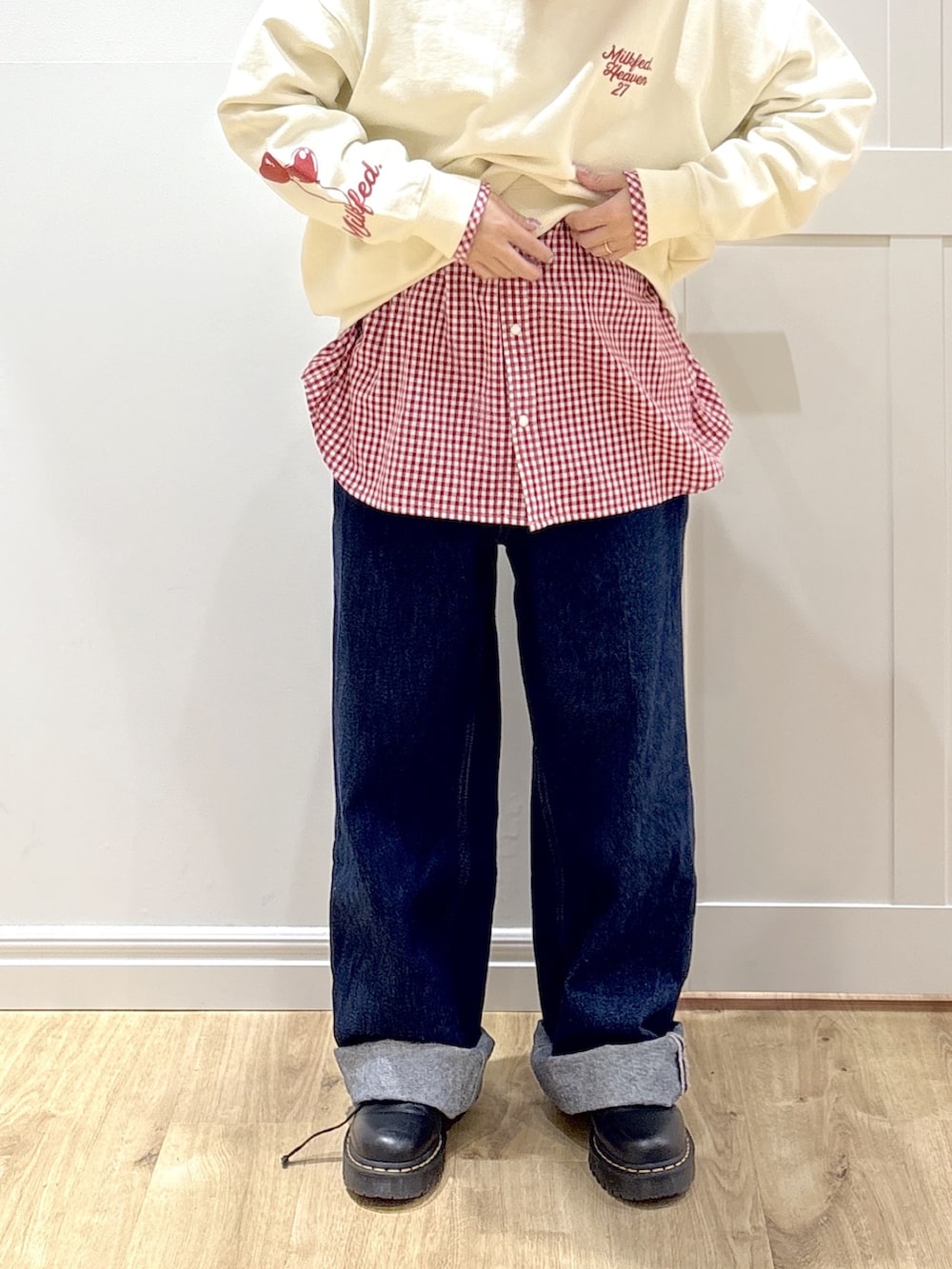 ブルー系のデニムパンツ、レッド系のシャツ/ブラウス、ホワイト系のショルダーバッグを着用したレディースの冬コーディネートの5枚目の写真