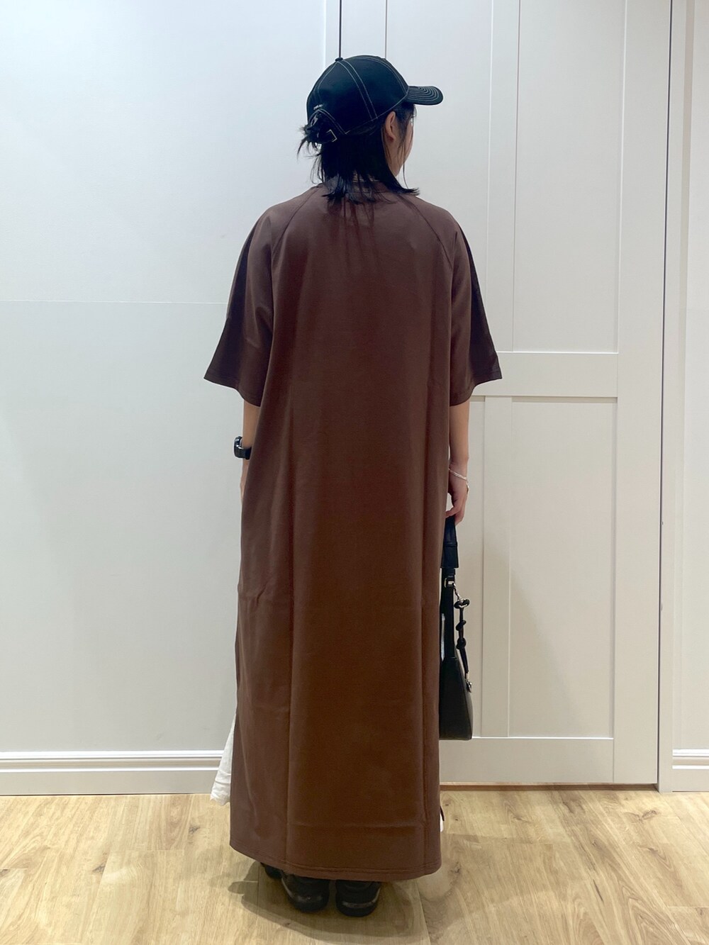 ブラック系のサンダル、ブラック系のハンドバッグ、ホワイト系のスカートを着用したレディースの春コーディネートの3枚目の写真