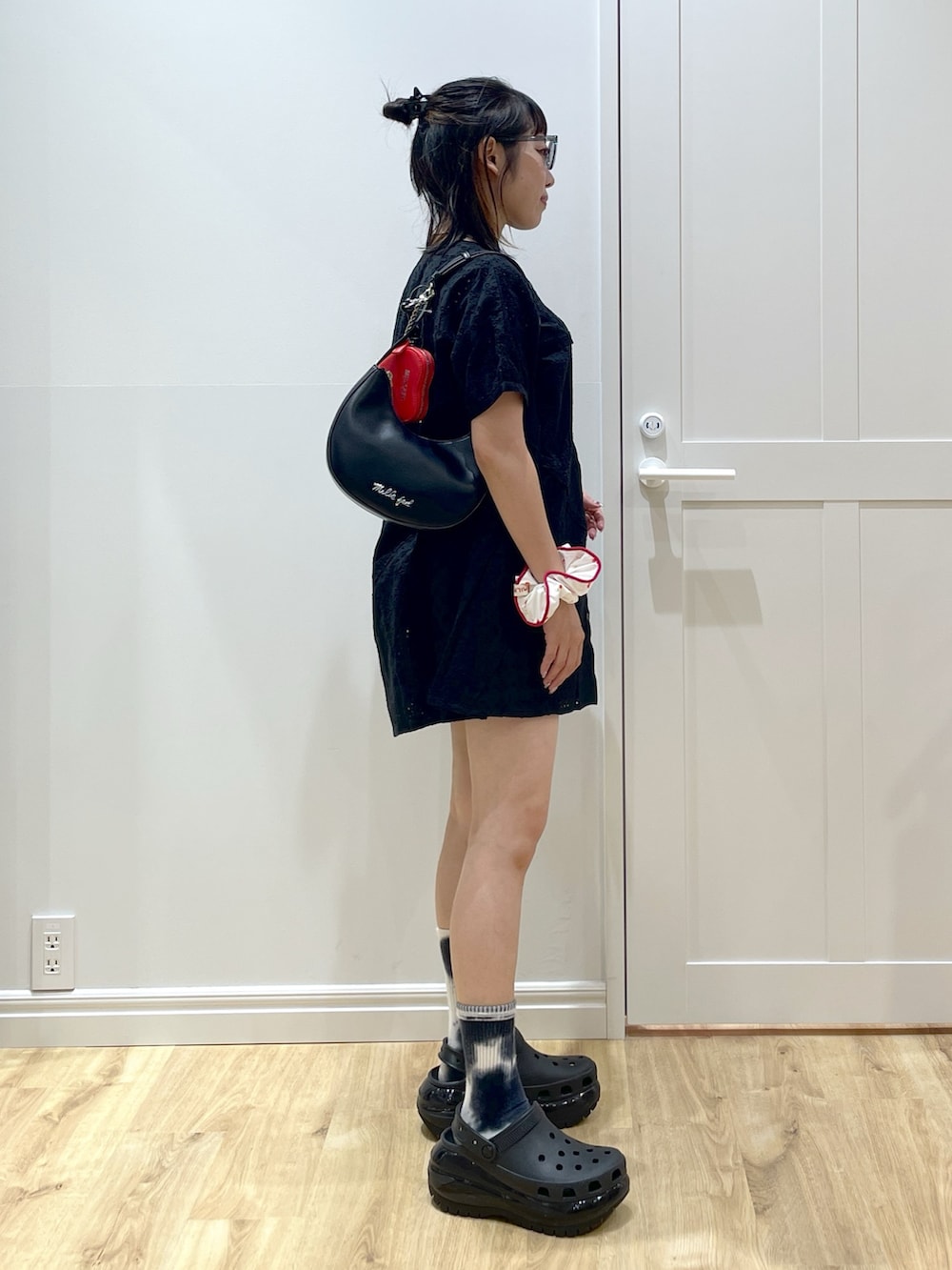 ブラック系のサンダル、ブラック系のワンピース、ブラック系のハンドバッグを着用したレディースの夏コーディネートの2枚目の写真