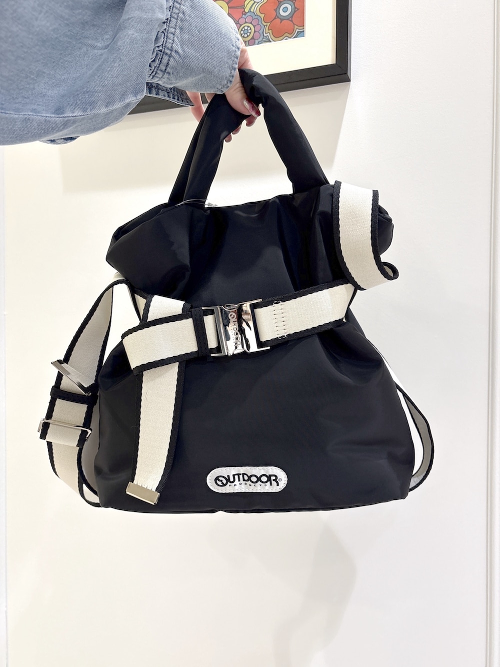 ブラック系のその他シューズ、ブラック系のトートバッグ、ブルー系のデニムパンツを着用したレディースの春コーディネートの6枚目の写真