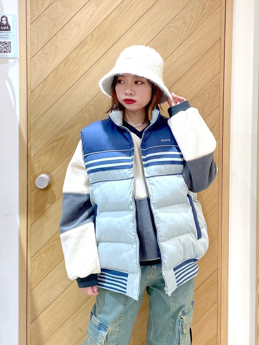 ブルー系のベスト、ブルー系のカーゴパンツ、ホワイト系のスニーカーを着用したレディースの秋コーディネートの3枚目の写真