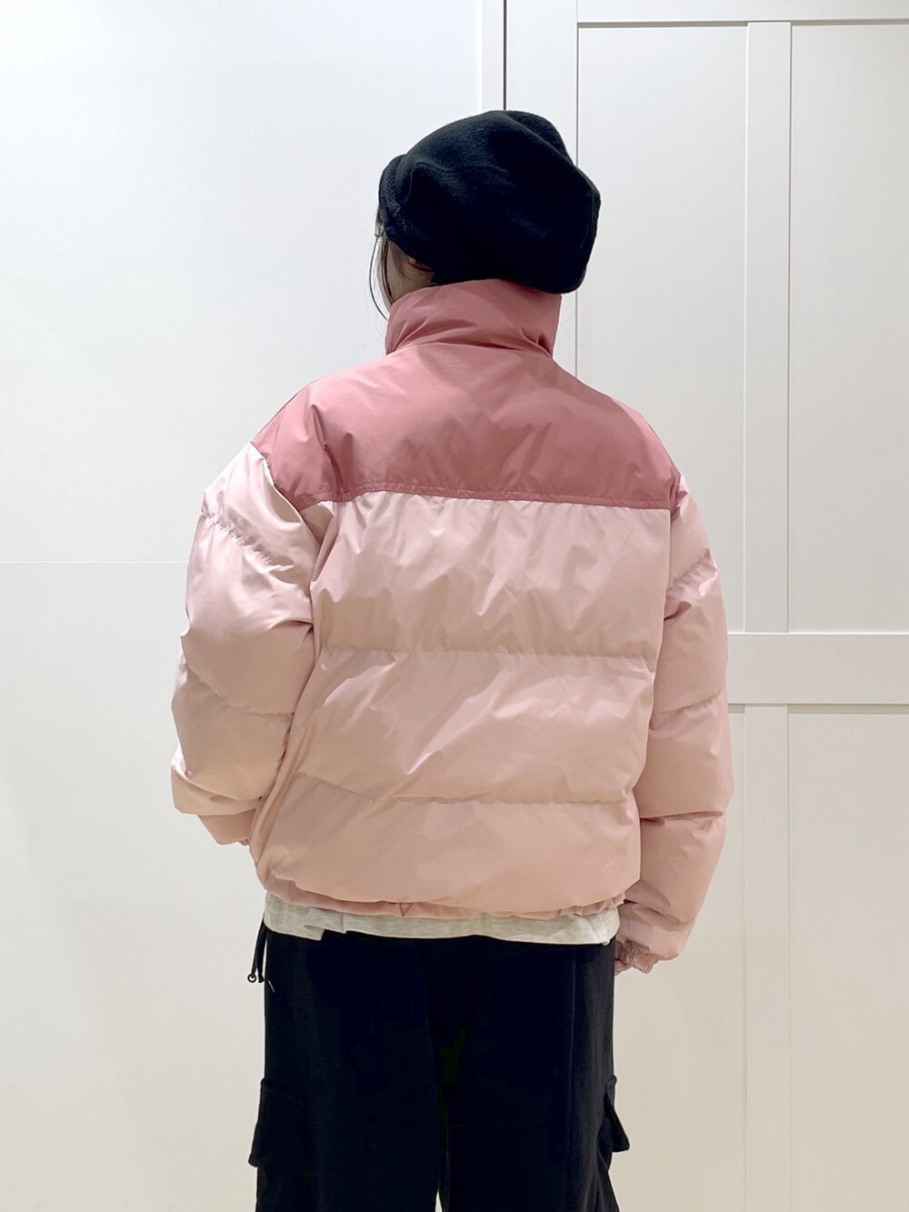 ブラック系のスウェットパンツ、ピンク系のダウンジャケット/コート、ベージュ系のTシャツ/カットソーを着用したレディースの冬コーディネートの5枚目の写真