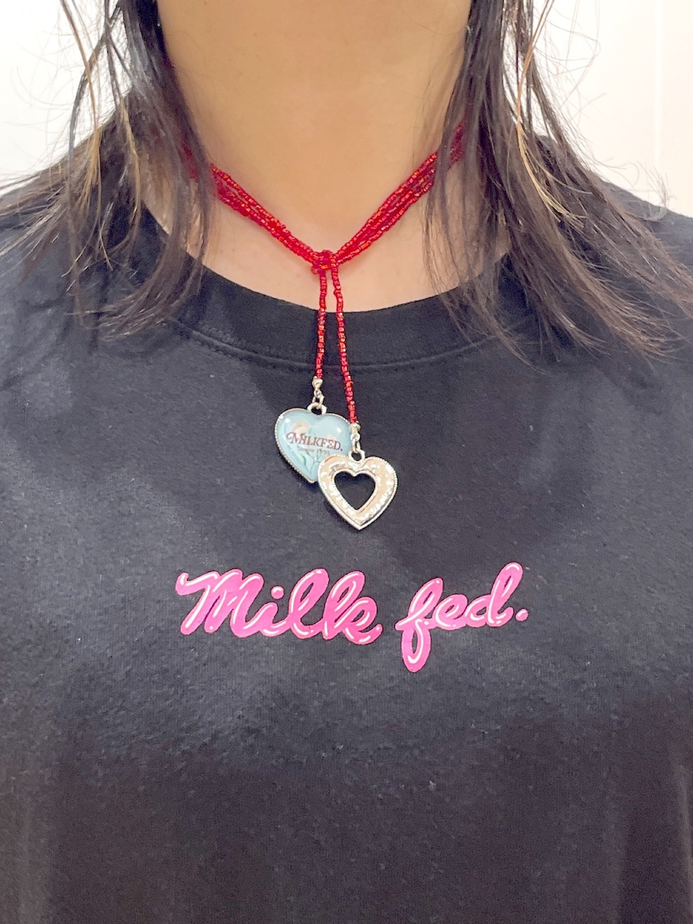 レッド系のトートバッグ、ブラック系のTシャツ/カットソー、ブラック系のスカートを着用したレディースの夏コーディネートの7枚目の写真