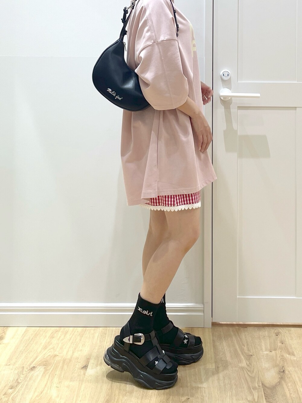 ブラウン系のTシャツ/カットソー、ブラック系のハンドバッグ、ブラック系のサンダルを着用したレディースの春コーディネートの3枚目の写真