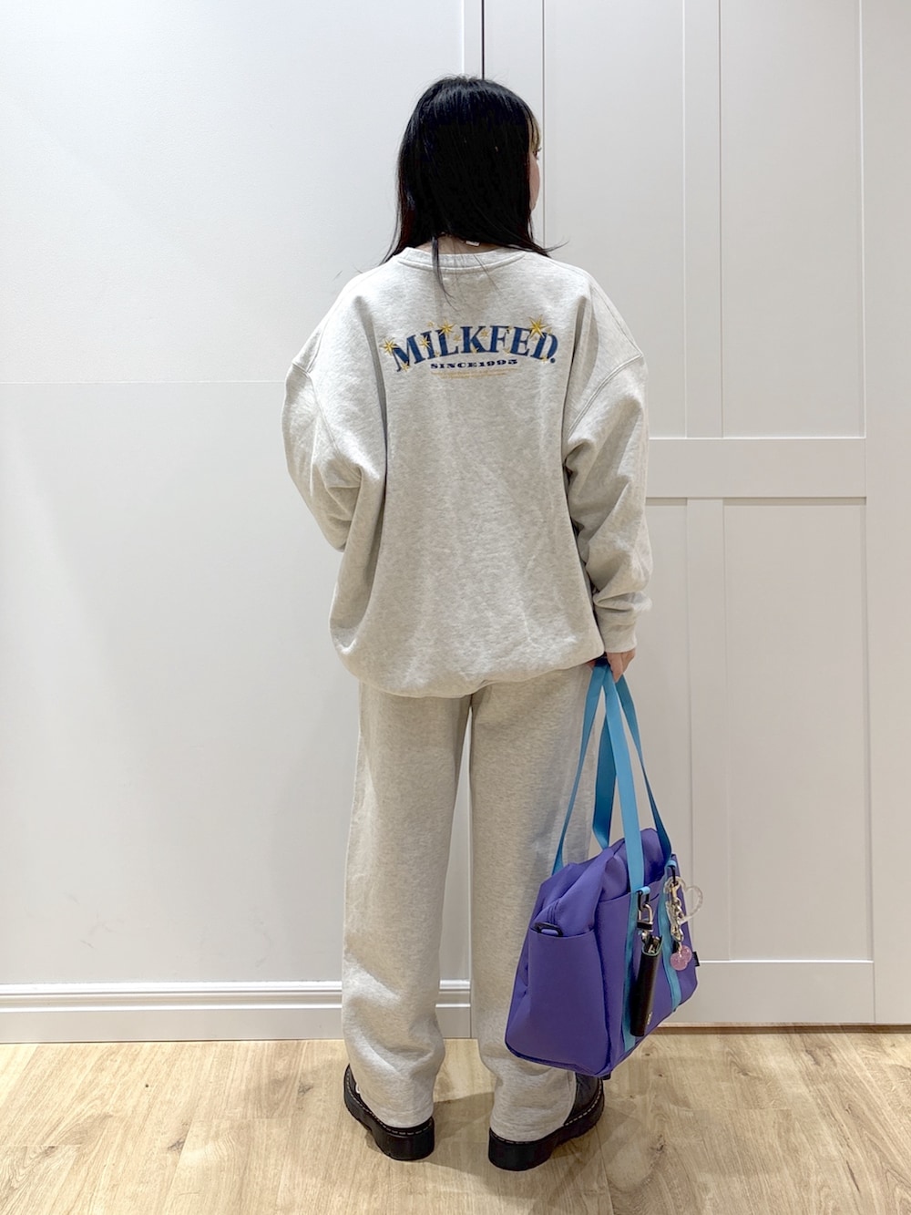 ベージュ系のスウェット、ベージュ系のスウェットパンツ、パープル系のショルダーバッグを着用したレディースの冬コーディネートの2枚目の写真