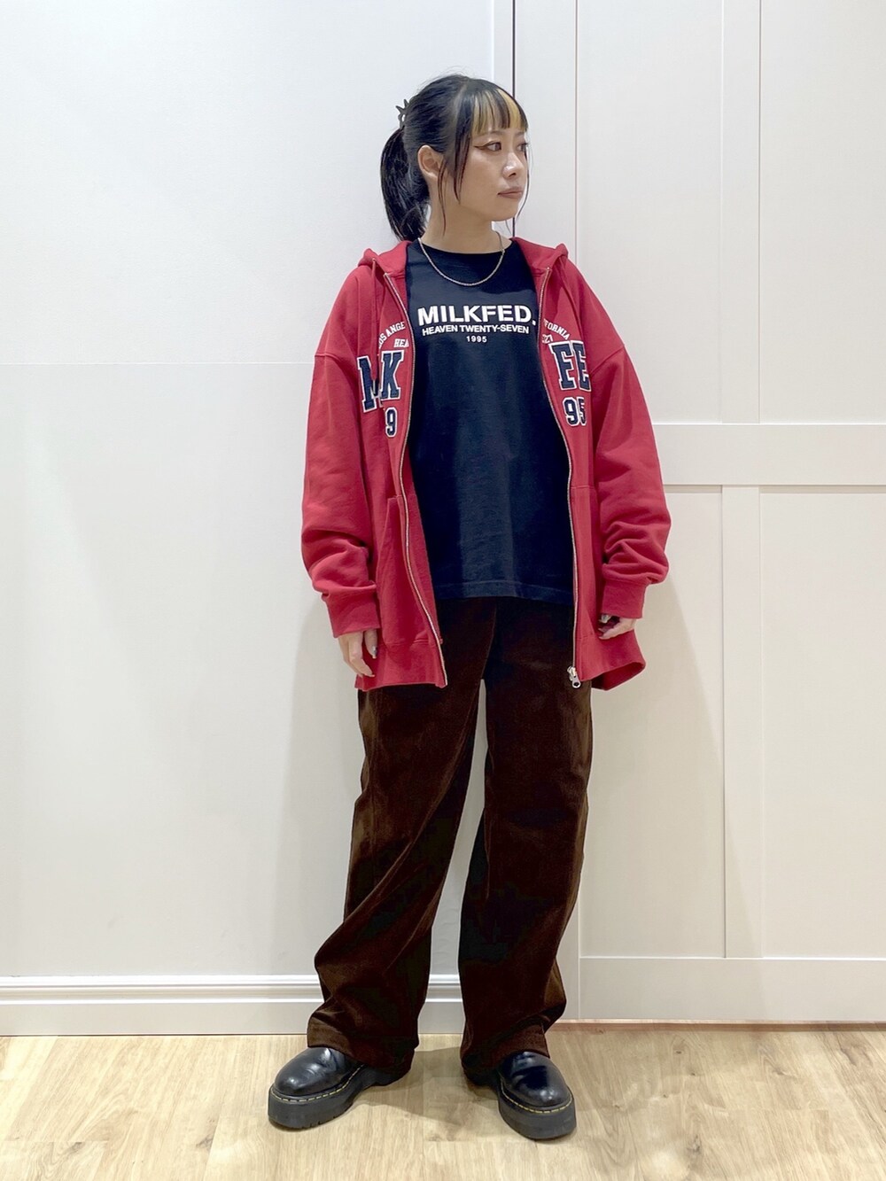 ブラック系のTシャツ/カットソー、レッド系のパーカー、ブラック系のブルゾンを着用したレディースの秋コーディネートの7枚目の写真