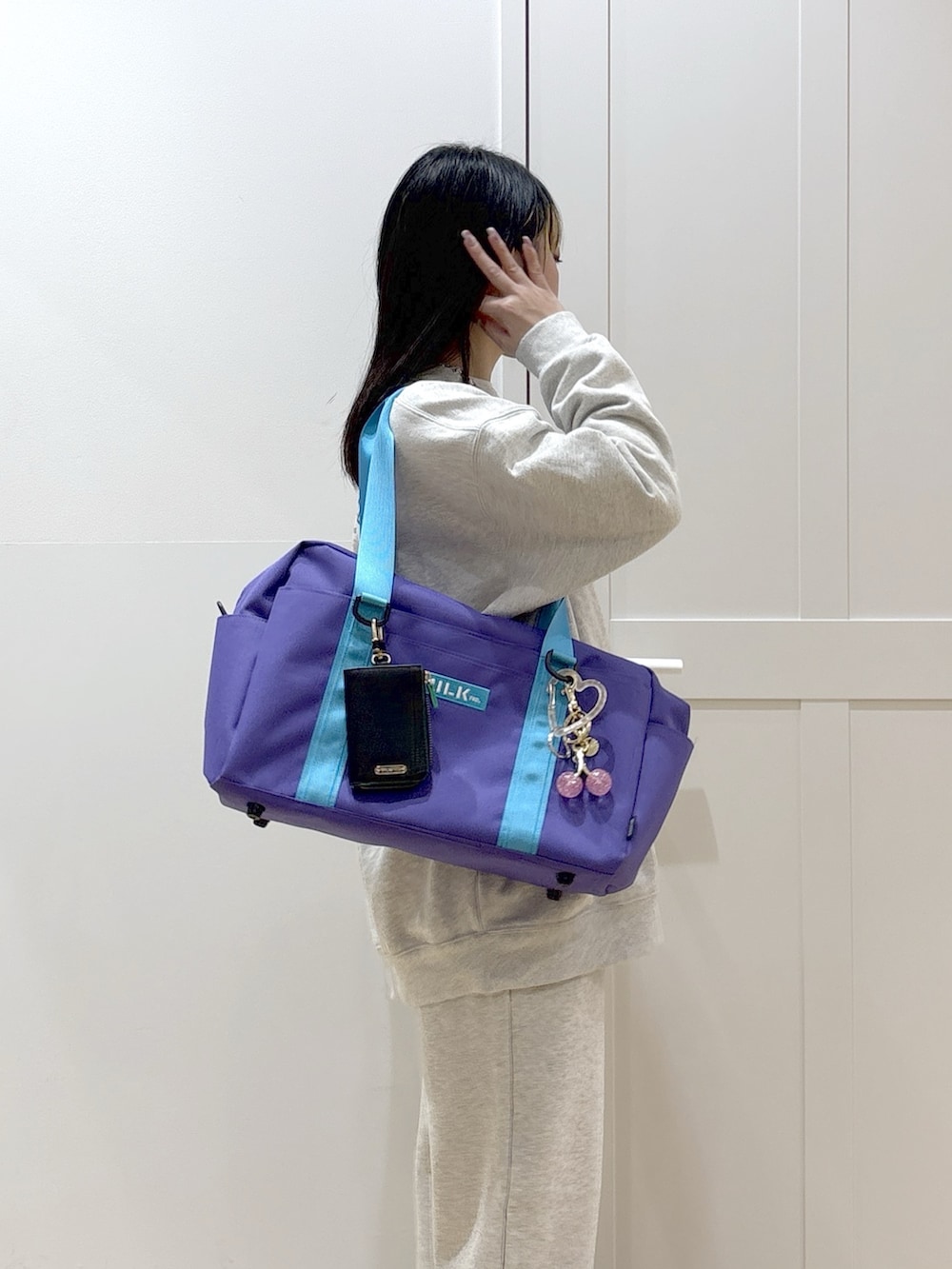 ベージュ系のスウェット、ベージュ系のスウェットパンツ、パープル系のショルダーバッグを着用したレディースの冬コーディネートの6枚目の写真