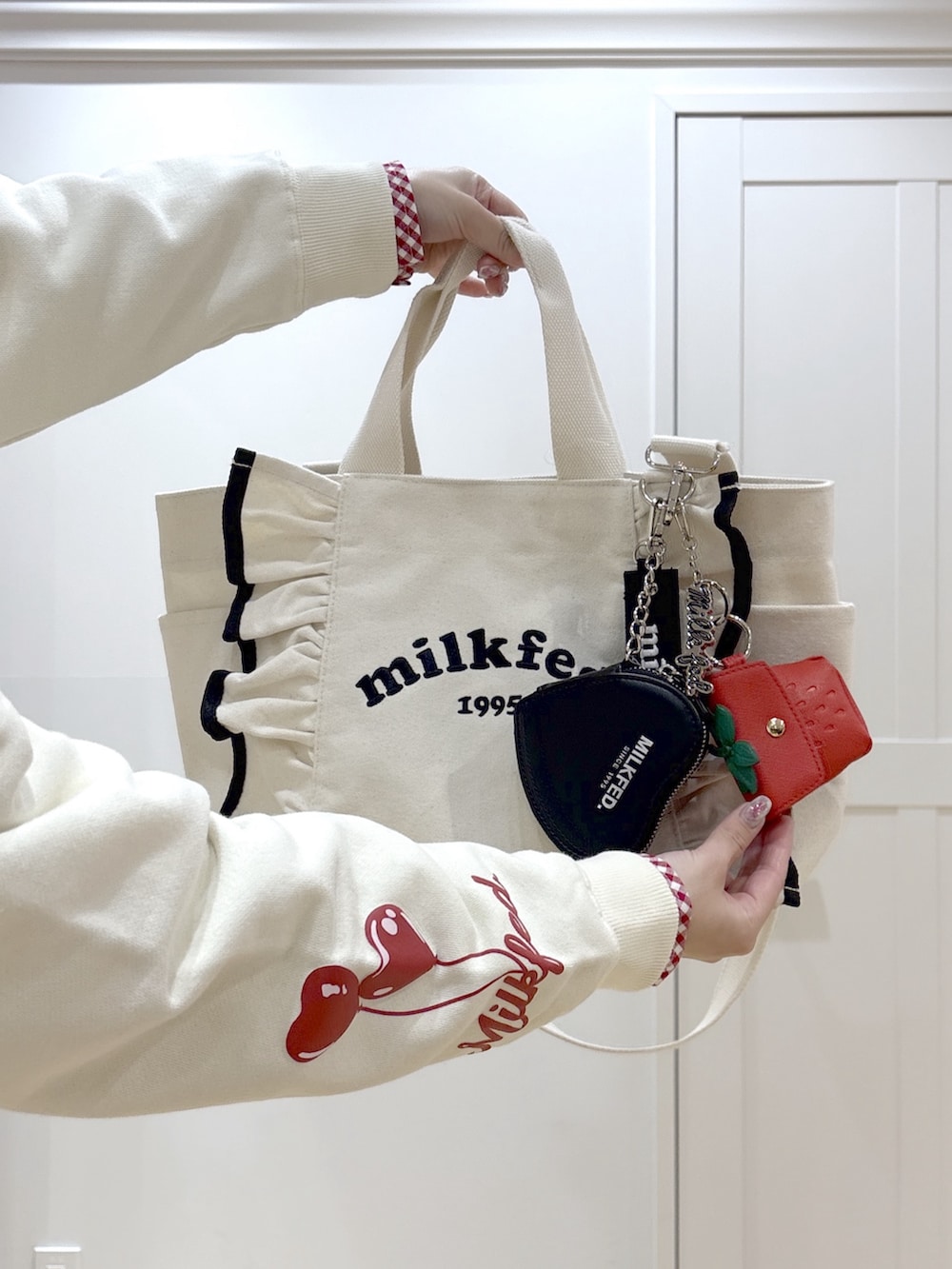 ブルー系のデニムパンツ、レッド系のシャツ/ブラウス、ホワイト系のショルダーバッグを着用したレディースの冬コーディネートの6枚目の写真