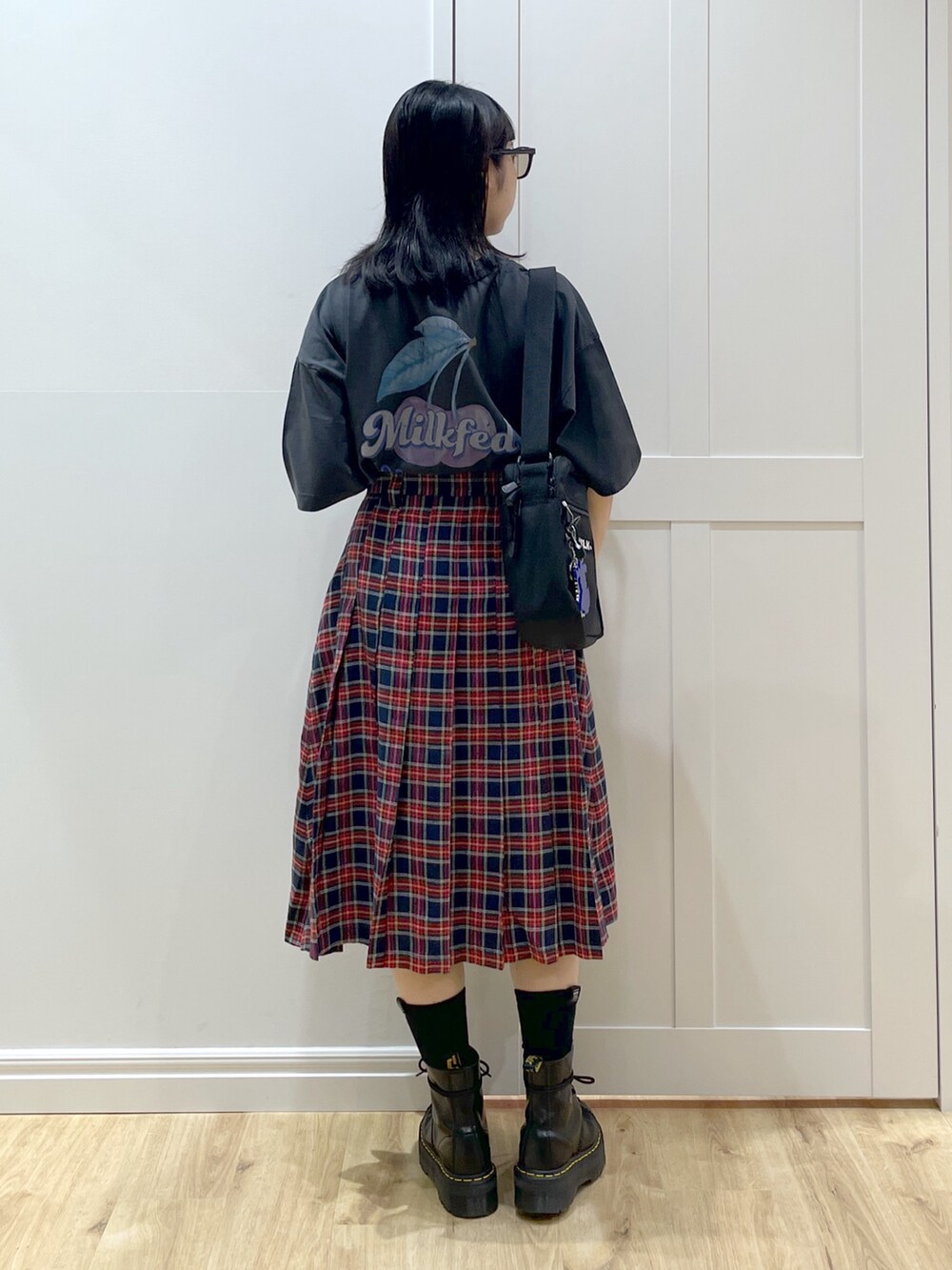 ブラック系のブーツ、ブルー系のスカート、グレー系のTシャツ/カットソーを着用したレディースの夏コーディネートの4枚目の写真