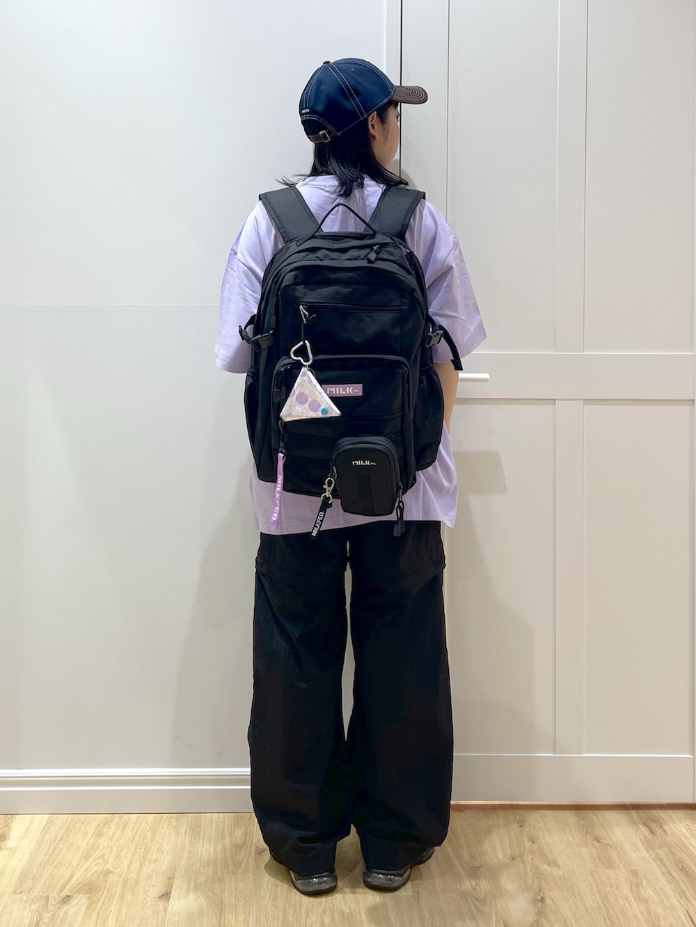 ブラック系のサンダル、ブラック系のその他パンツ、パープル系のTシャツ/カットソーを着用したレディースの夏コーディネートの3枚目の写真