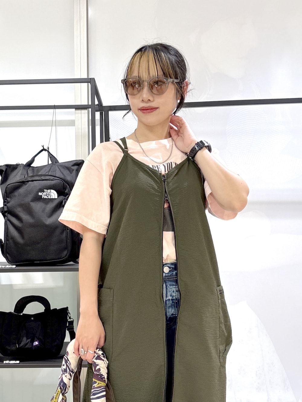 ブラック系のスニーカー、ピンク系のTシャツ/カットソー、ブラウン系のトートバッグを着用したレディースの春コーディネートの6枚目の写真