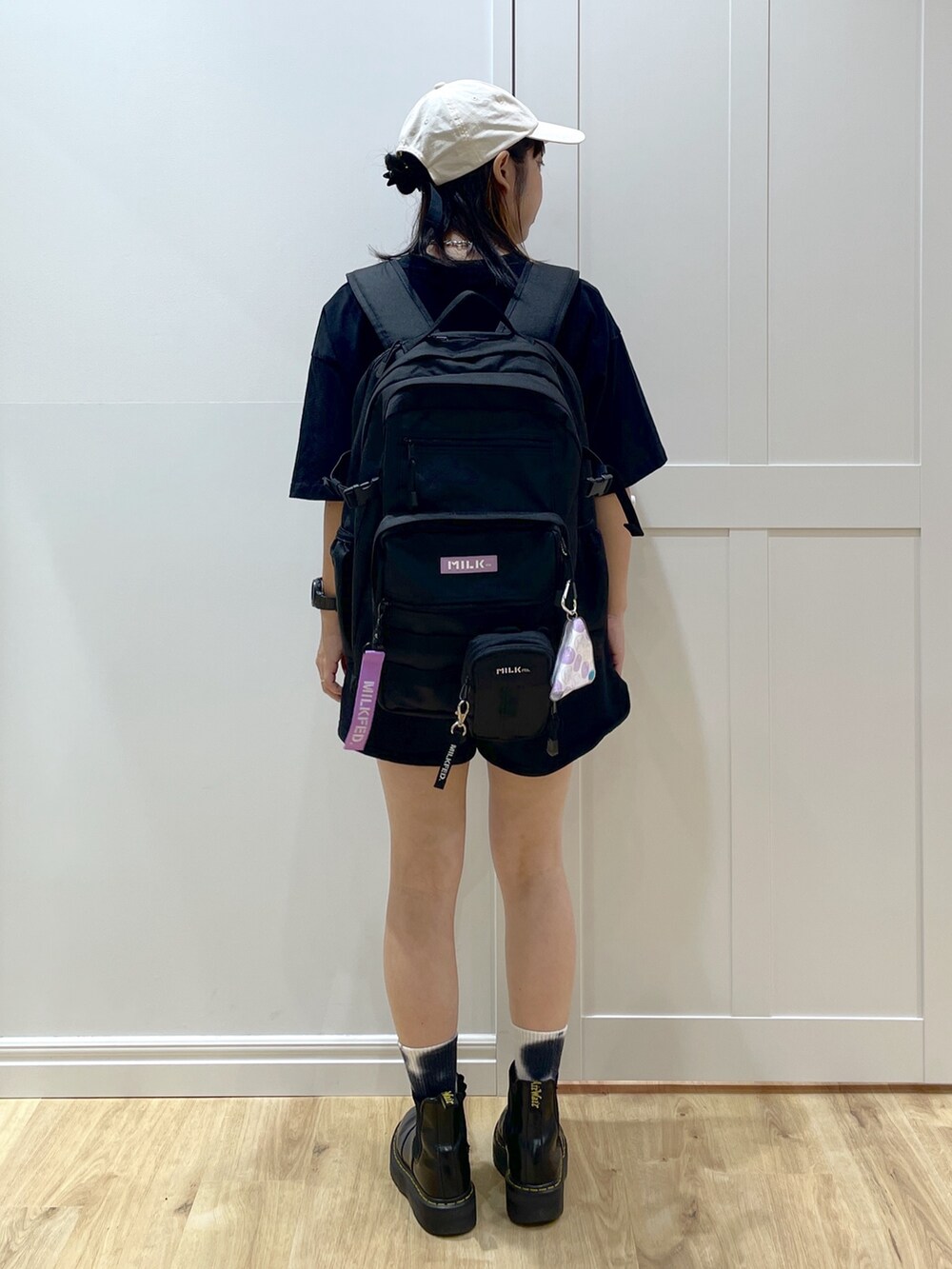 パープル系のバックパック/リュック、ブラック系のショルダーバッグ、ブラック系のブーツを着用したレディースの夏コーディネートの5枚目の写真