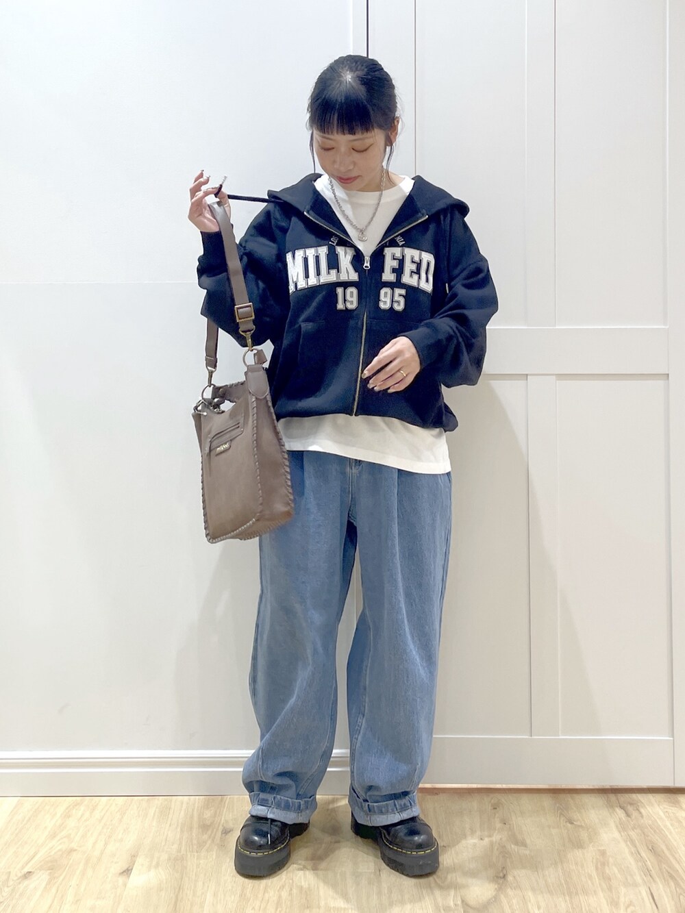 ブラック系のブーツ、ホワイト系のTシャツ/カットソー、ブラック系のパーカーを着用したレディースの秋コーディネートの2枚目の写真