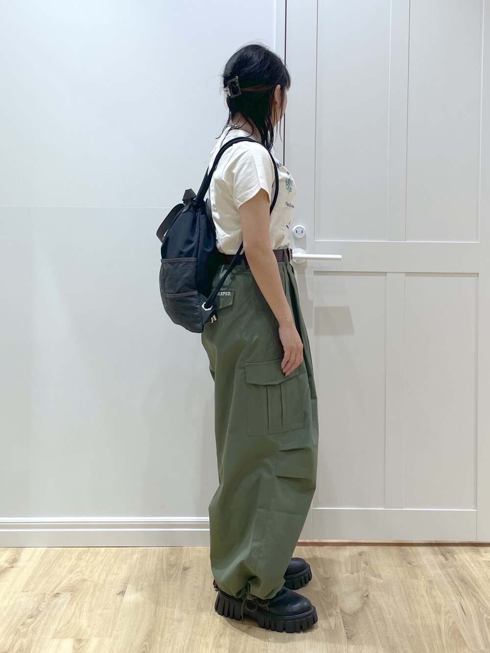グリーン系のその他パンツ、ホワイト系のTシャツ/カットソー、ブラック系のバックパック/リュックを着用したレディースの春コーディネートの2枚目の写真