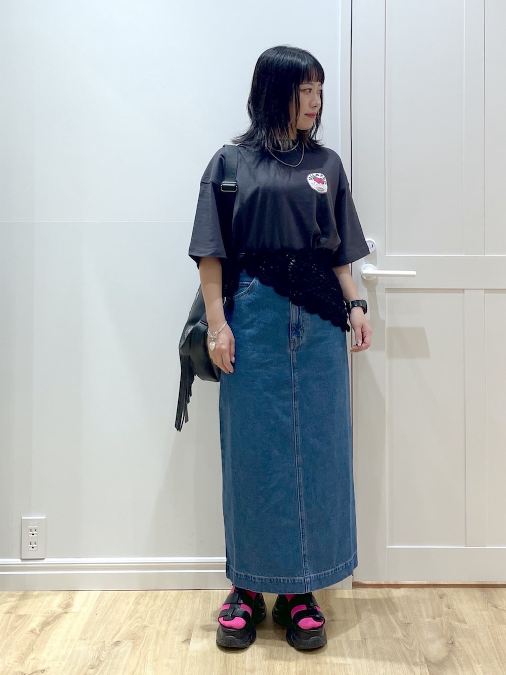 ブラック系のショルダーバッグ、グレー系のTシャツ/カットソー、ブルー系のデニムスカートを着用したレディースの夏コーディネートの4枚目の写真