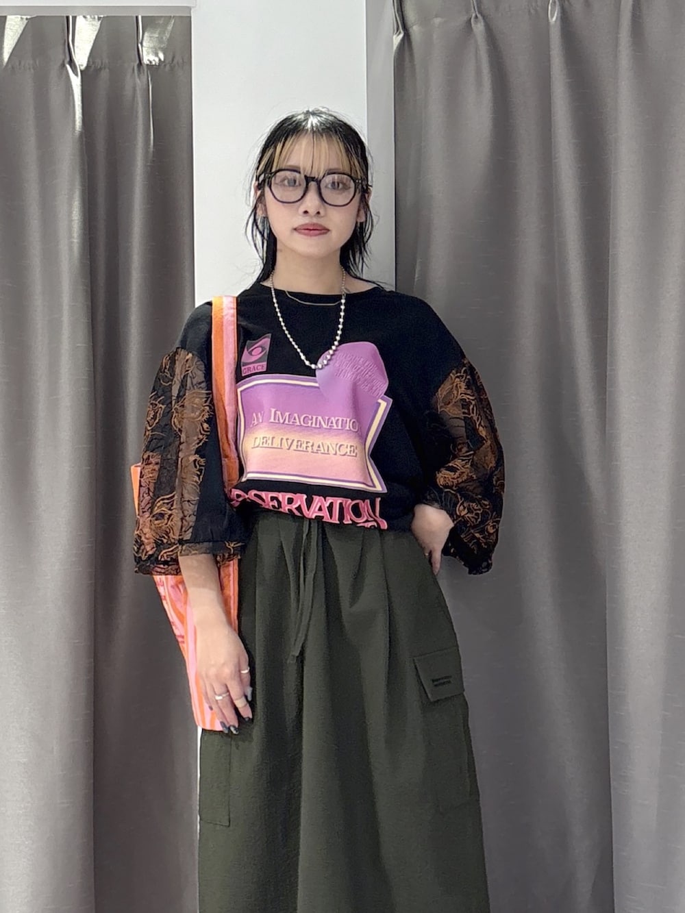 ブラック系のTシャツ/カットソー、グリーン系のスカート、ブラック系のパンプスを着用したレディースの夏コーディネートの5枚目の写真