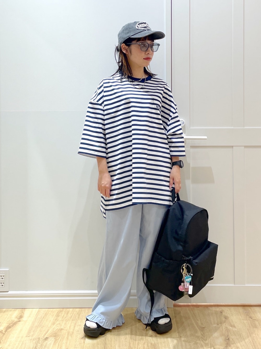 ブラック系のバックパック/リュック、ブルー系のその他パンツ、ブラック系のサンダルを着用したレディースの夏コーディネートの2枚目の写真