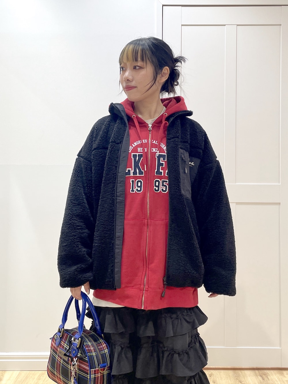 ブラック系のブーツ、ブラック系のショルダーバッグ、ブラック系のスカートを着用したレディースの冬コーディネートの5枚目の写真