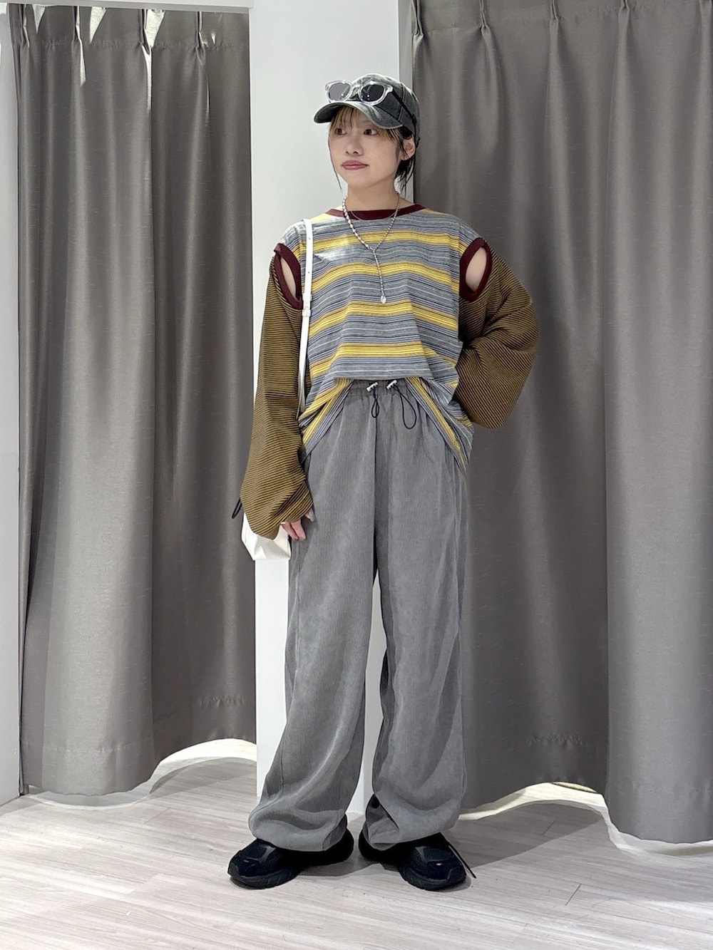 グレー系のその他パンツ、イエロー系のTシャツ/カットソー、ブラック系のスニーカーを着用したレディースの夏コーディネートの2枚目の写真