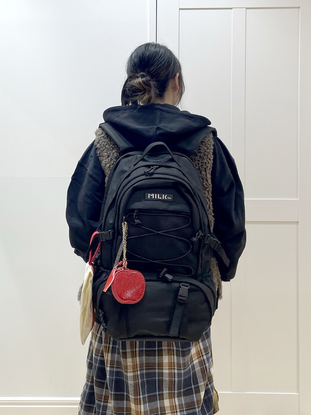 ブラウン系のベスト、イエロー系のワンピース、ブラック系のブーツを着用したレディースの冬コーディネートの8枚目の写真