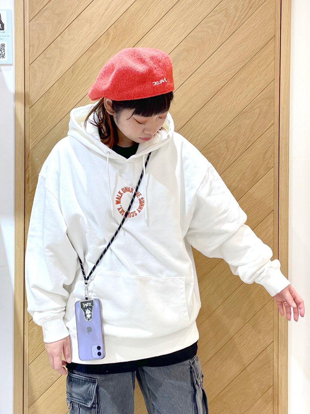 ホワイト系のパーカー、ブラック系のカーゴパンツ、ブラック系のブーツを着用したレディースの冬コーディネートの3枚目の写真