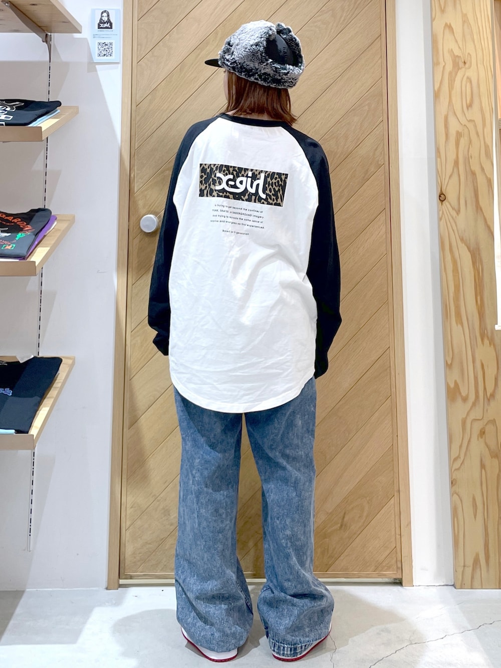 ブルー系のデニムパンツ、レッド系のスニーカー、ホワイト系のTシャツ/カットソーを着用したレディースの秋コーディネートの2枚目の写真