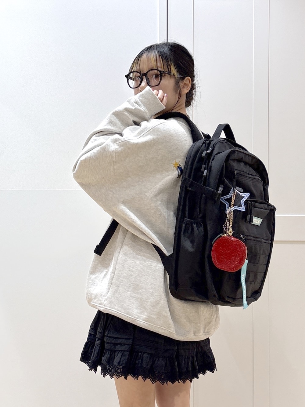 ブラック系のスカート、ベージュ系のスウェット、グリーン系のバックパック/リュックを着用したレディースの春コーディネートの8枚目の写真