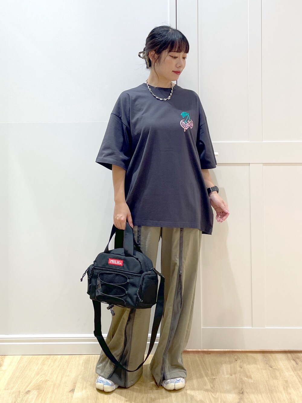 グリーン系のその他パンツ、グレー系のTシャツ/カットソー、レッド系のショルダーバッグを着用したレディースの夏コーディネートの2枚目の写真