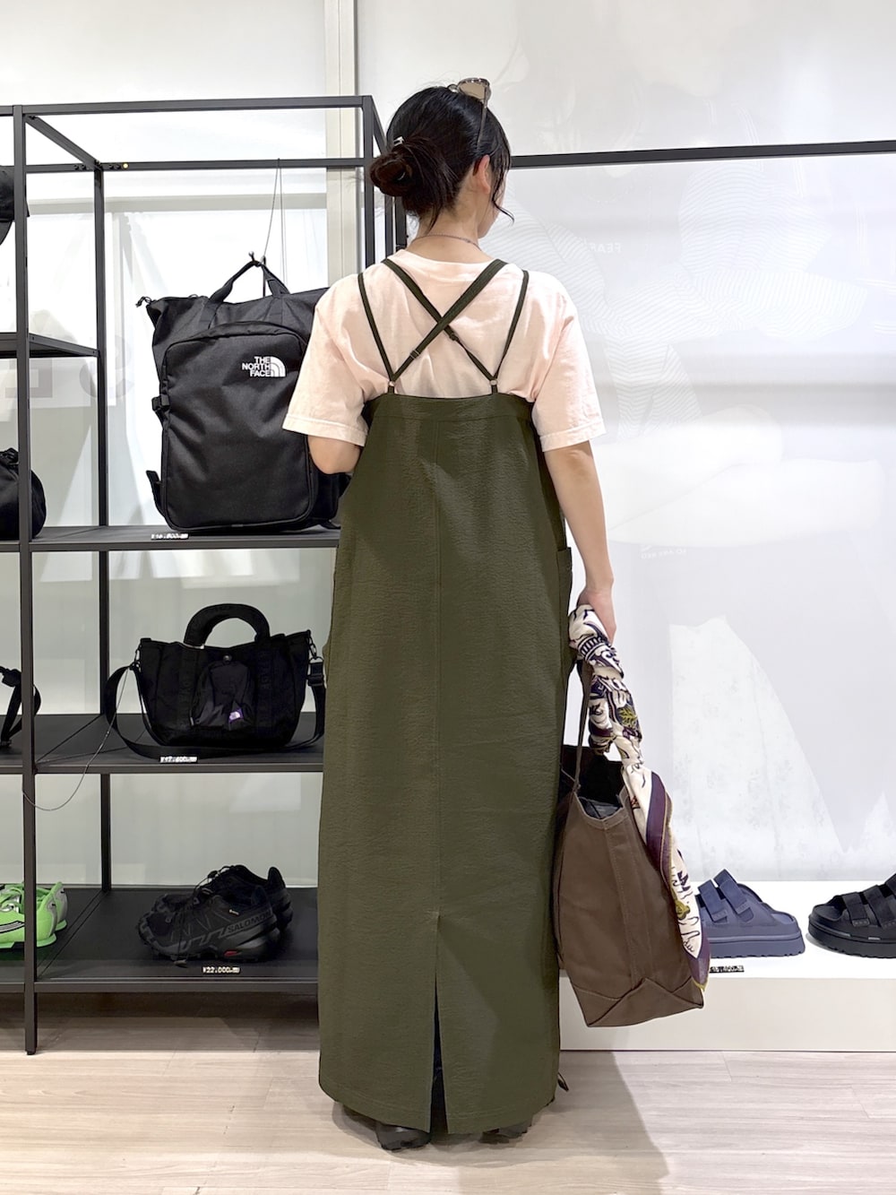 ブラック系のスニーカー、ピンク系のTシャツ/カットソー、ブラウン系のトートバッグを着用したレディースの春コーディネートの2枚目の写真
