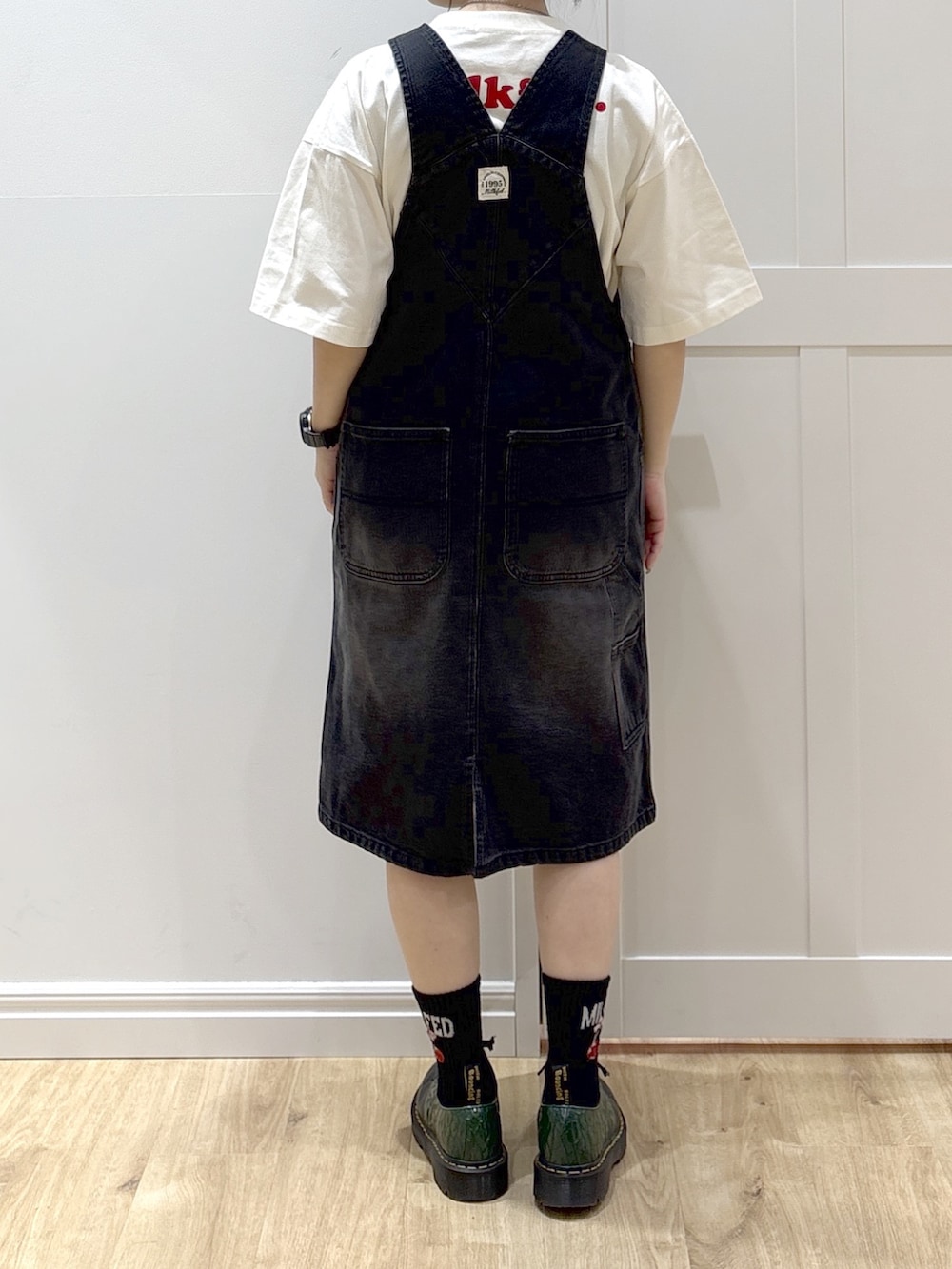 ブラック系のサロペット/オーバーオール、イエロー系のカーディガン/ボレロ、ホワイト系のTシャツ/カットソーを着用したレディースの春コーディネートの8枚目の写真