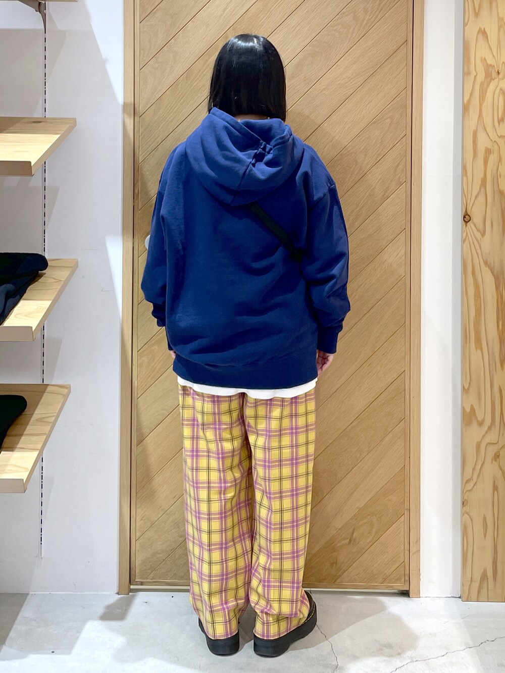 イエロー系のその他パンツ、ブラック系のブーツ、ブルー系のパーカーを着用したレディースの冬コーディネートの2枚目の写真