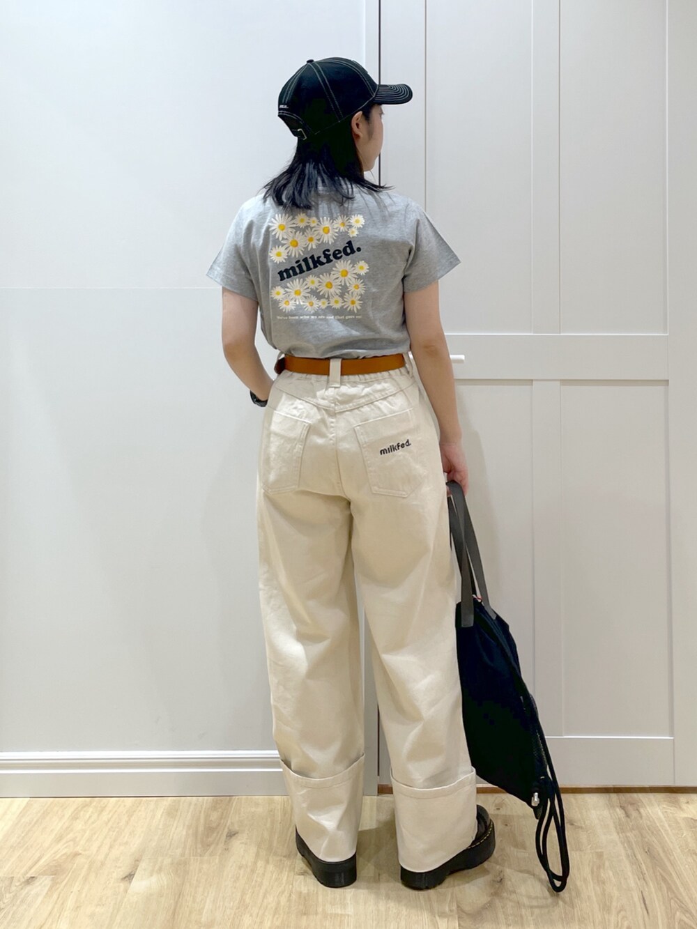 ホワイト系のデニムパンツ、ブラック系のブーツ、グレー系のTシャツ/カットソーを着用したレディースの夏コーディネートの3枚目の写真