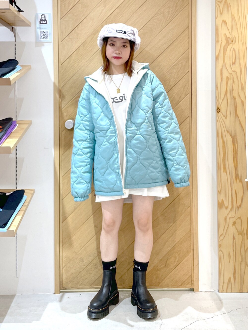 ホワイト系のTシャツ/カットソー、ホワイト系のナイロンジャケット、ブラック系のブーツを着用したレディースの秋コーディネートの2枚目の写真