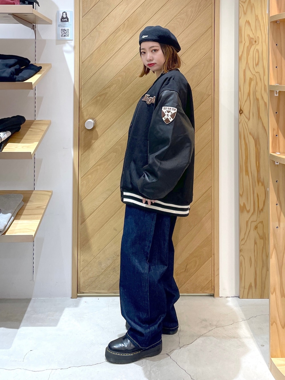 ブラック系のニット/セーター、ブラック系のスタジャン、ブラック系のブーツを着用したレディースの秋コーディネートの3枚目の写真