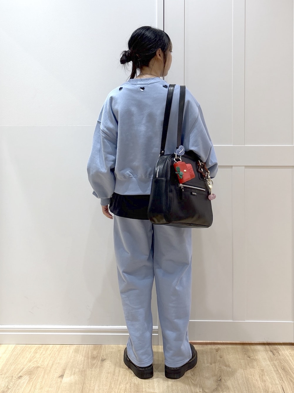 ブラック系のブーツ、ブルー系のスウェットパンツ、グリーン系のボストンバッグを着用したレディースの春コーディネートの4枚目の写真