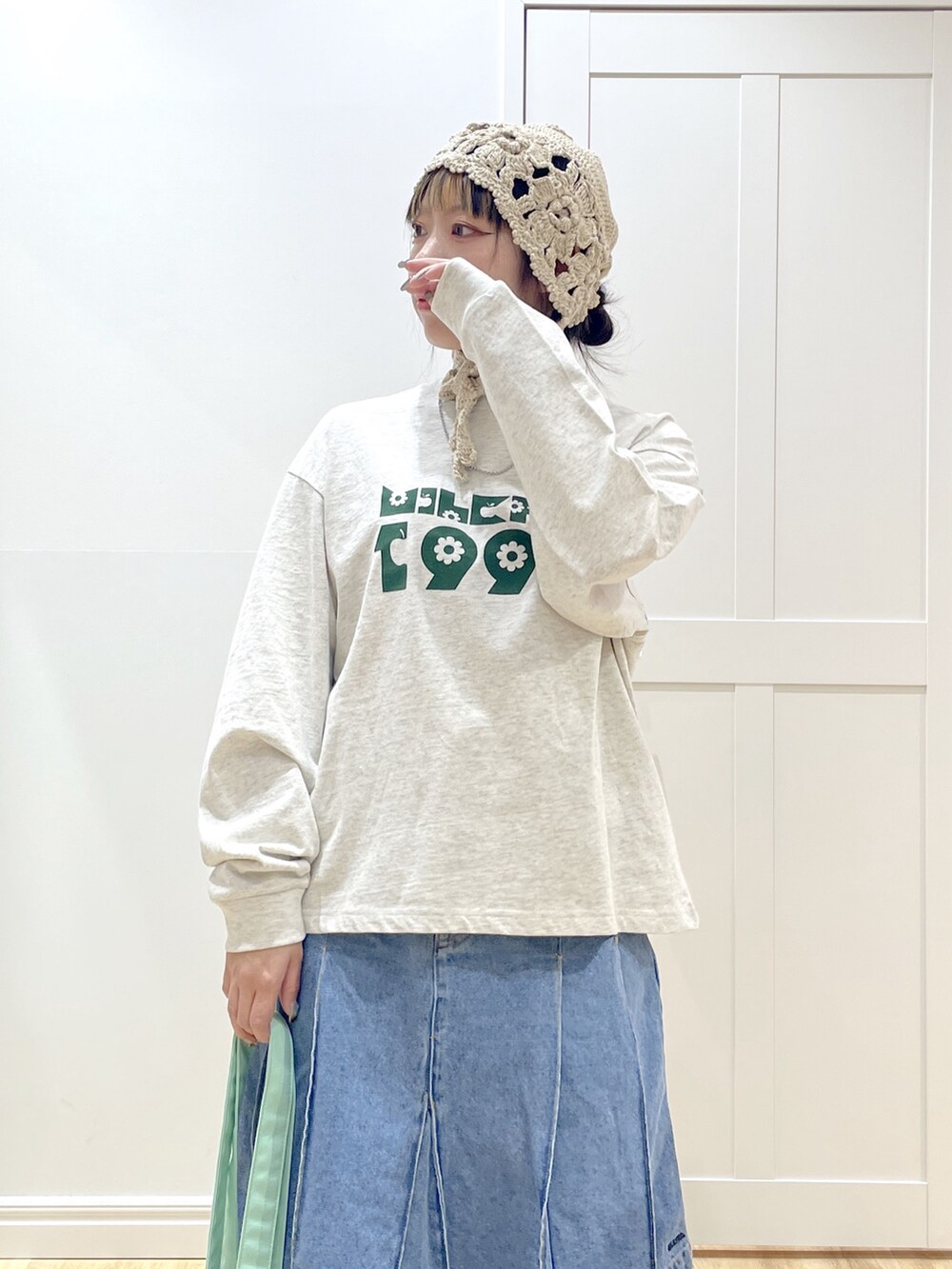 ホワイト系のダウンジャケット/コート、ベージュ系のTシャツ/カットソー、ブルー系のデニムパンツを着用したレディースの冬コーディネートの7枚目の写真