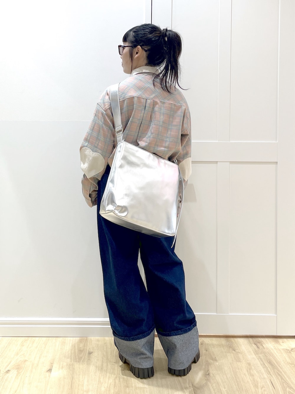 ブルー系のデニムパンツ、ピンク系のシャツ/ブラウス、シルバー系のショルダーバッグを着用したレディースの秋コーディネートの2枚目の写真