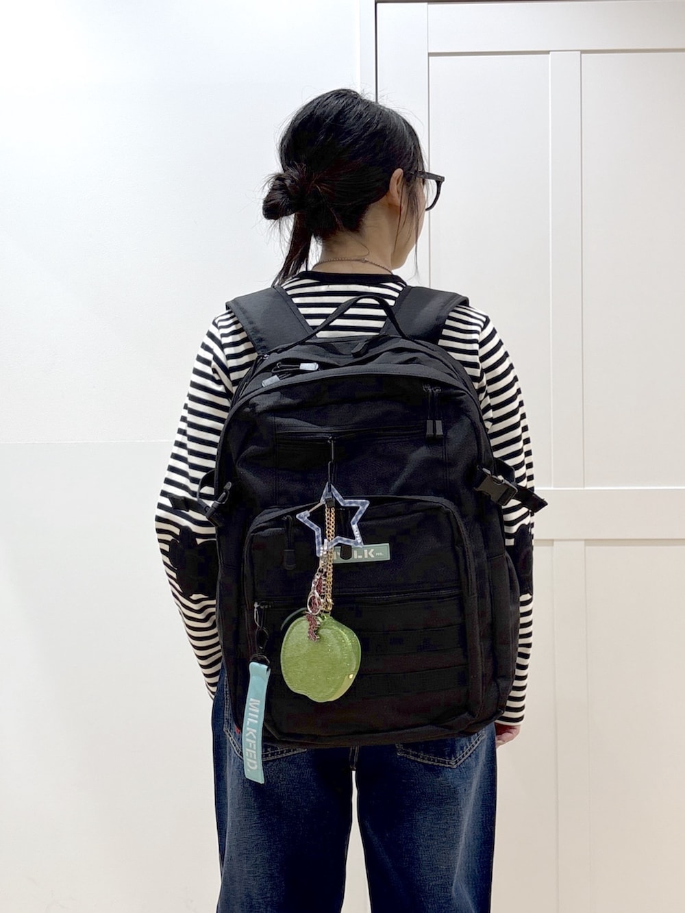 ブルー系のデニムパンツ、ブラック系のブーツ、ブラック系のカーディガン/ボレロを着用したレディースの春コーディネートの6枚目の写真